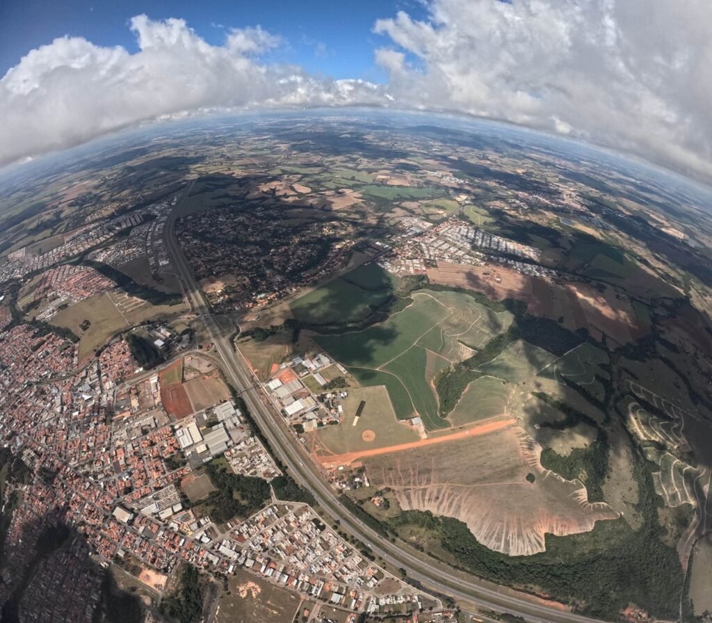 Gorgeous aerial view showcasing urban and rural landscapes with fields and clouds.